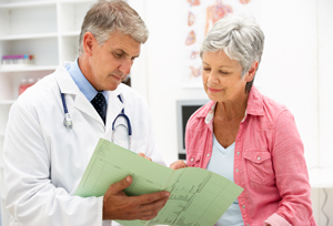 A male Physician is going over a female patients information with her